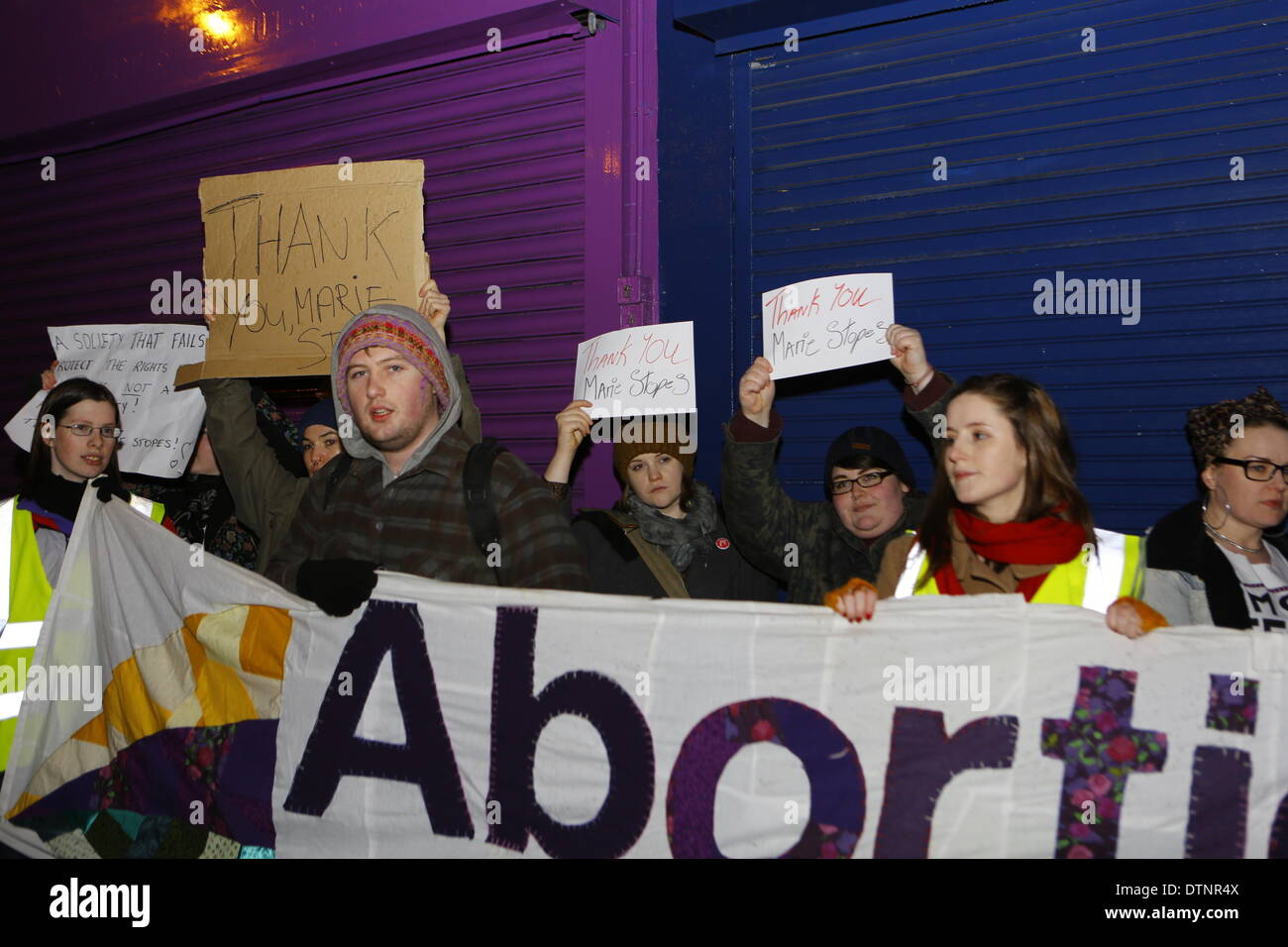 Dublin, Ireland. 21st February 2014. Activists stand outside the pro-life counselling office holding up signs in support of the Marie Stopes Centre. Irish pro-choice activists protested outside the counselling offices of Good Counsel Network Ireland in Dublin. The offices are located directly next to a Marie Stopes Centre, which provides pro-choice pregnancy counselling services. Credit:  Michael Debets/Alamy Live News Stock Photo