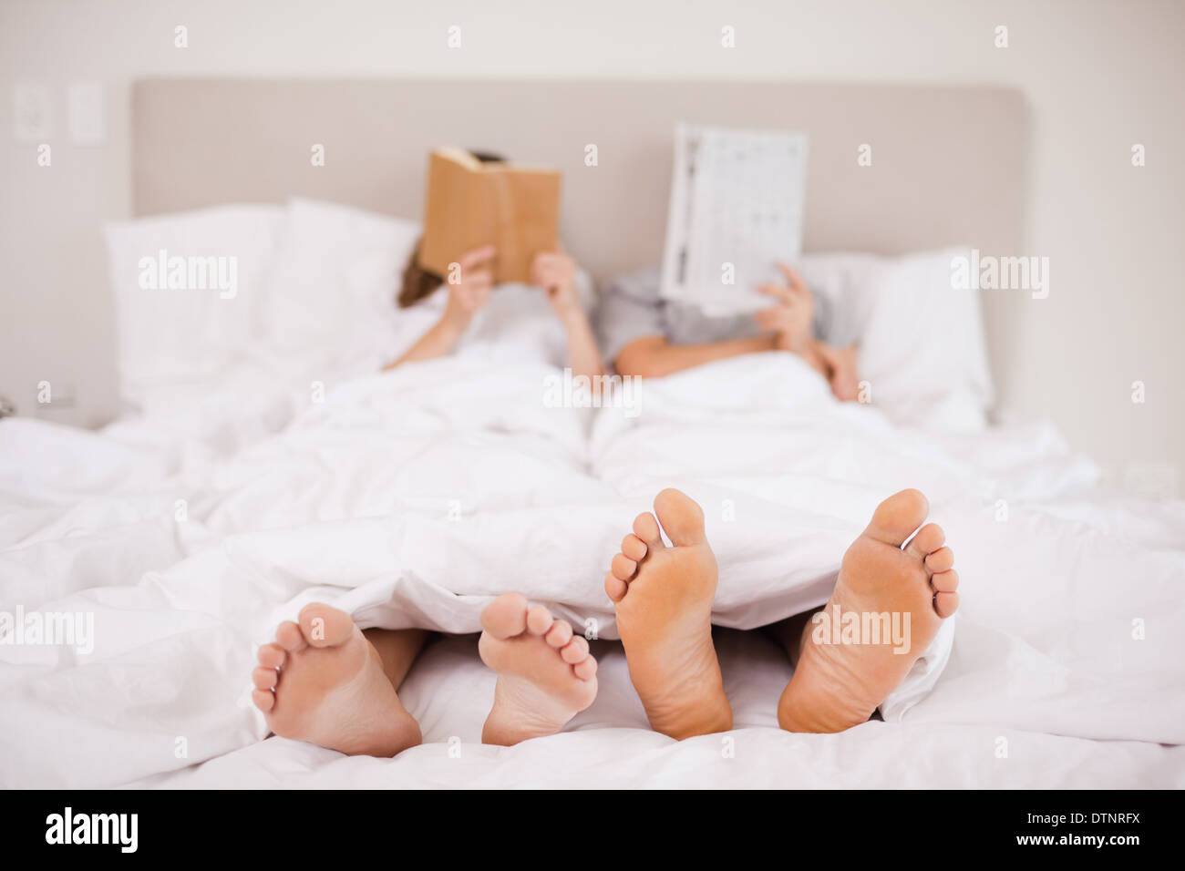 Couple reading while hiding their faces Stock Photo