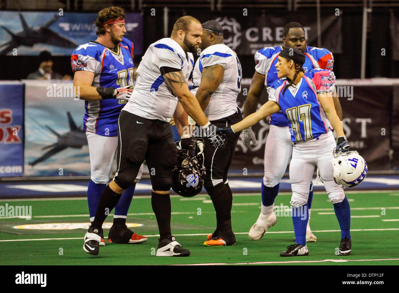 Allen, TX, USA. 21st Feb, 2014. Jennifer Welter (right) shakes hands with Cedar Rapids Titans' defensive lineman Ben Pister after the Texas Revolution defeated the Titans in an Indoor Football League game at the Allen Event Center Friday, February 21, 2014, in Allen, Texas. The 5-foot-2-inch, 130 pound Welter is the first woman to play professional football at a position other than kicker, she made the final roster of the Texas Revolution of the Indoor Football League, as a running back. © csm/Alamy Live News Stock Photo