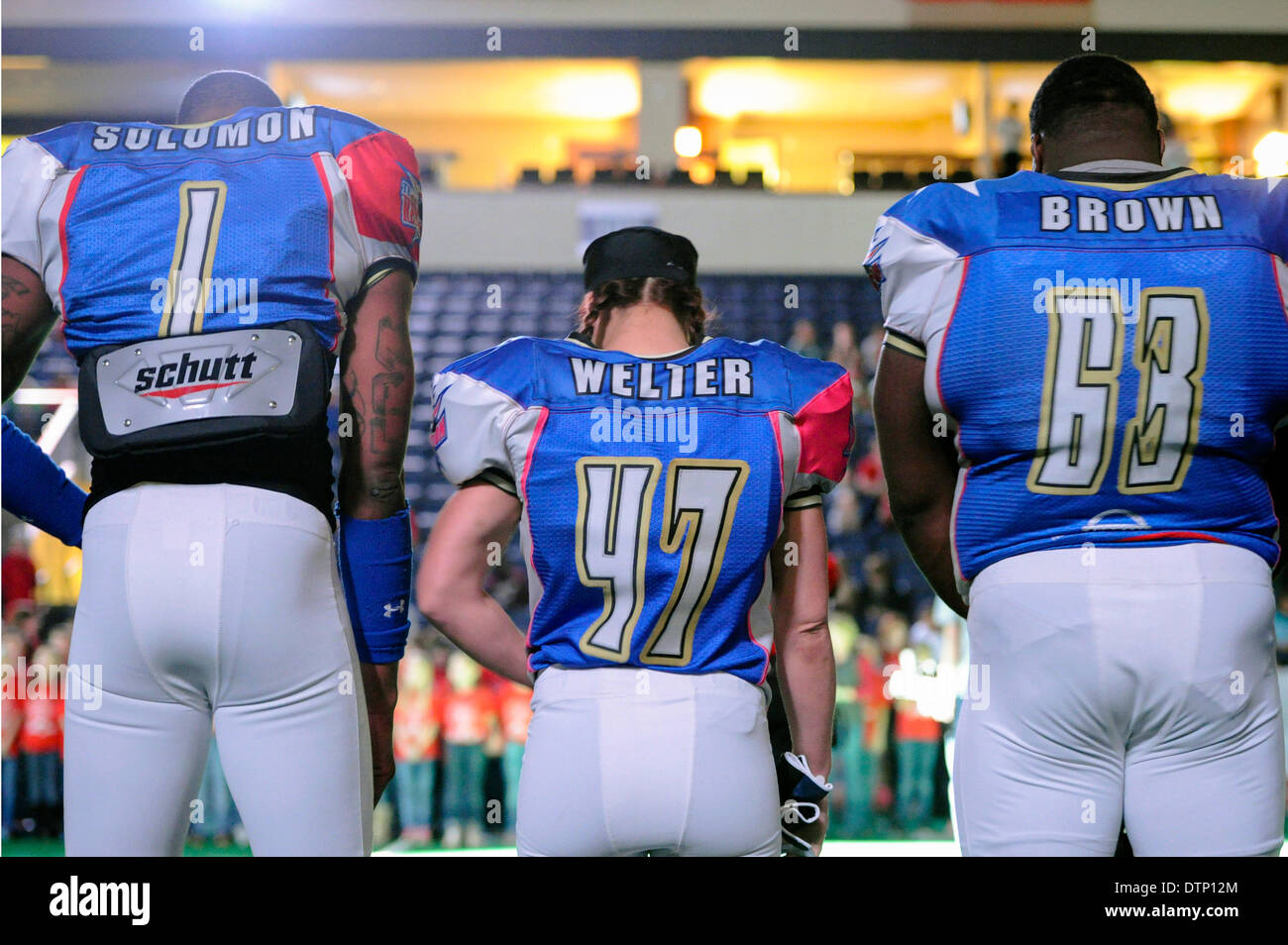 Allen, TX, USA. 21st Feb, 2014. Texas Revolution running back Jennifer Welter (47) is flanked by receiver Clinton Solomon (1) and offensive lineman Chris Brown (63) during a pre game payer prior to the Revolution playing the Cedar Rapids Titans in an Indoor Football League game at the Allen Event Center Friday, February 21, 2014, in Allen, Texas. The 5-foot-2-inch, 130 pound Welter is the first woman to play professional football at a position other than kicker, she made the final roster of the Texas Revolution of the Indoor Football League, as a running back. © csm/Alamy Live News Stock Photo