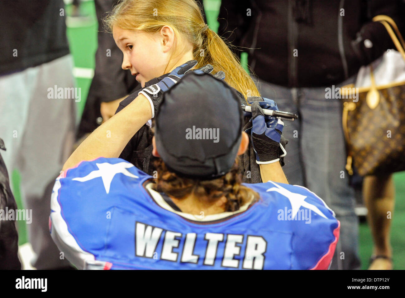 Allen, TX, USA. 21st Feb, 2014. Texas Revolution running back Jennifer Welter signs an autograph for 8-year-old Amrie Clower after the Revolution defeated the Cedar Rapids Titans in an Indoor Football League game at the Allen Event Center Friday, February 21, 2014, in Allen, Texas. The 5-foot-2-inch, 130 pound Welter is the first woman to play professional football at a position other than kicker, she made the final roster of the Texas Revolution of the Indoor Football League, as a running back. © csm/Alamy Live News Stock Photo