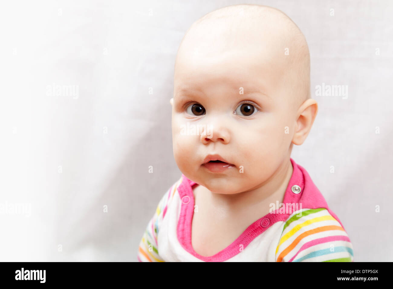 Little brown eyed Caucasian baby girl closeup studio portrait Stock Photo