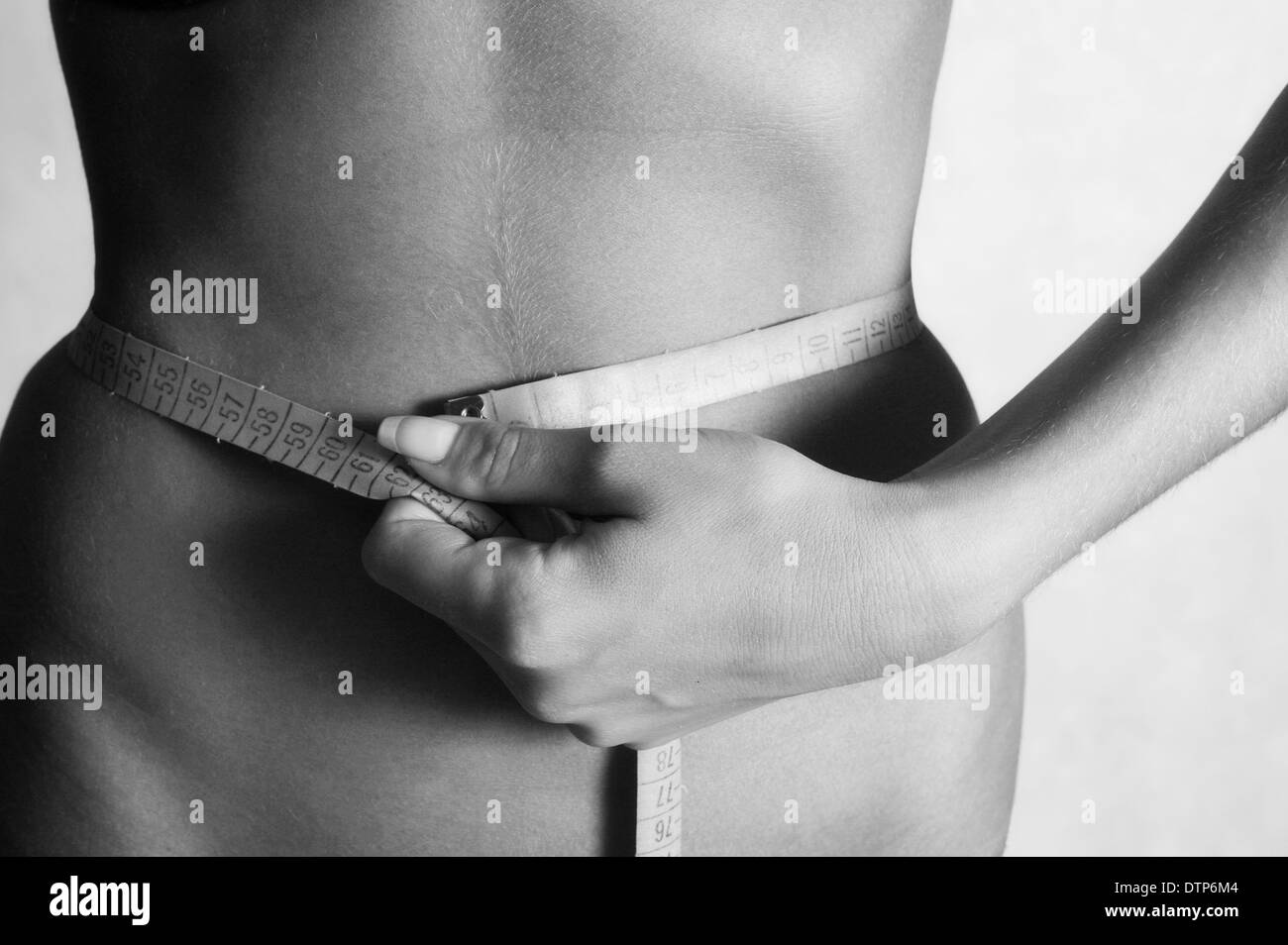 The young woman measures to itself a waist of sm Stock Photo