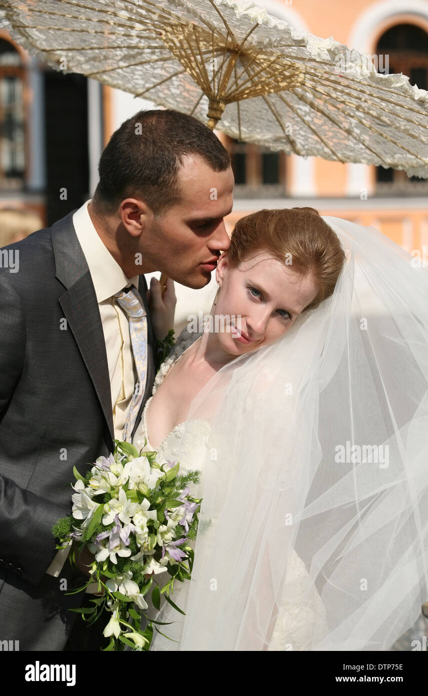 The groom and the bride kiss in park Stock Photo - Alamy