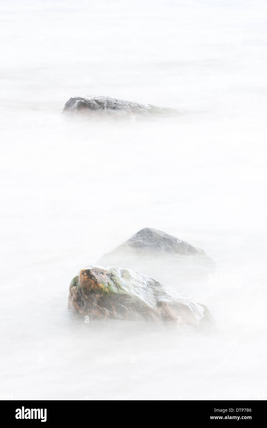 Three rocks in soft white water Stock Photo