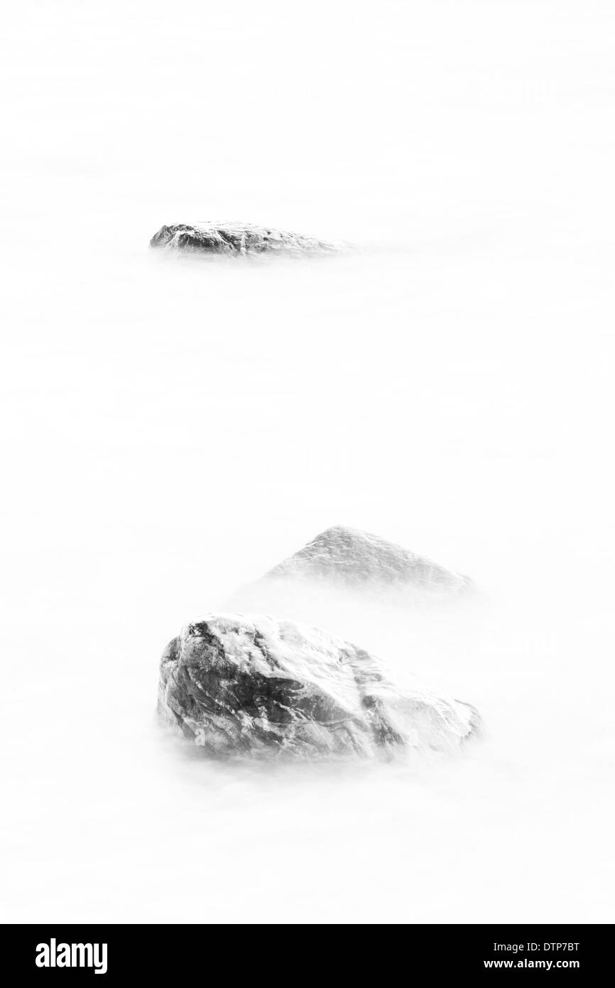 Three rocks in soft white water Stock Photo