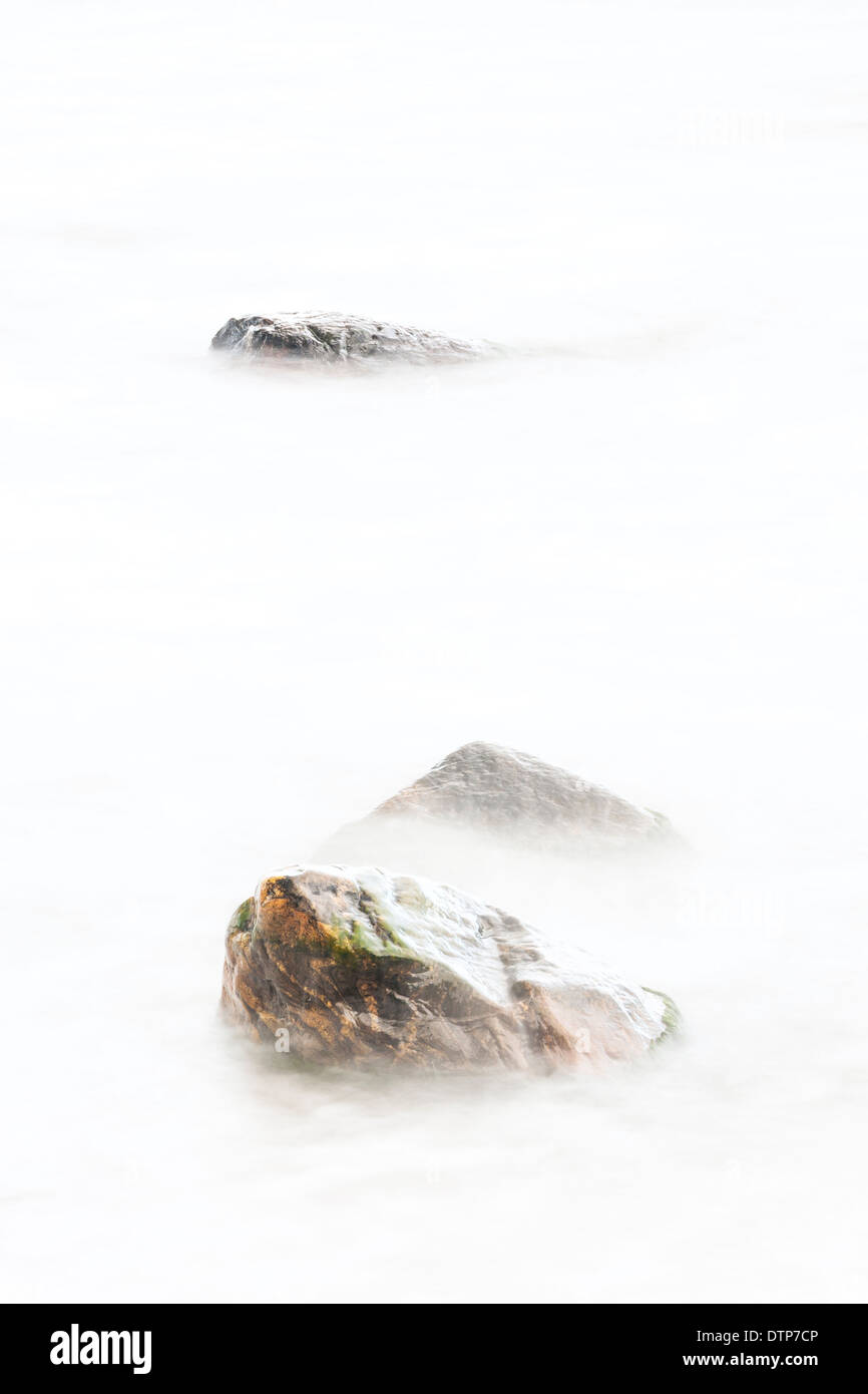 Three rocks in soft white water Stock Photo