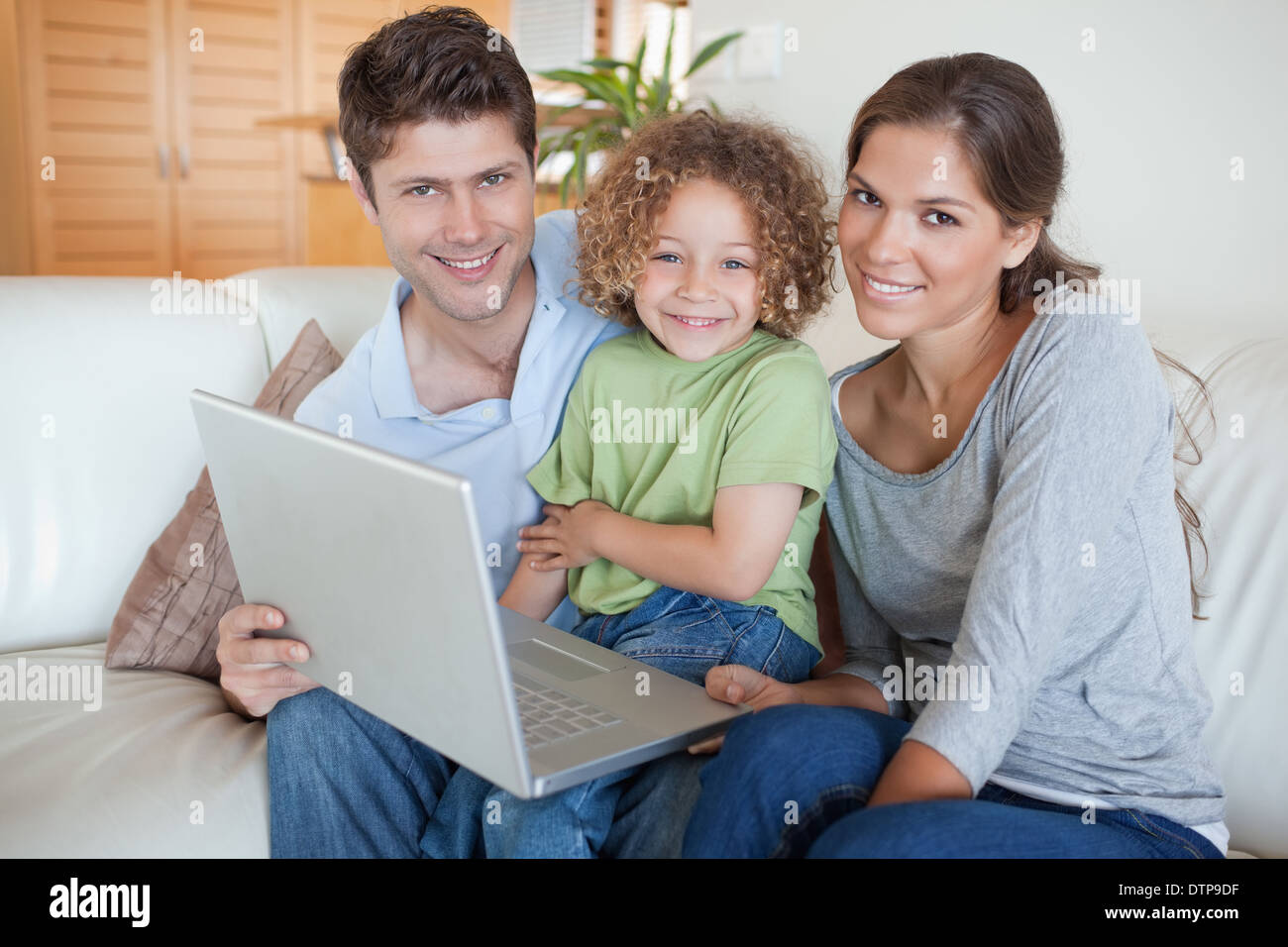Happy family using a laptop Stock Photo - Alamy