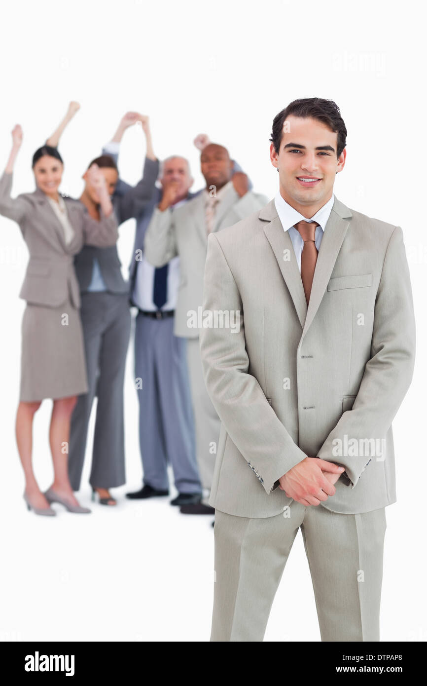 Businessman with cheering team behind him Stock Photo - Alamy