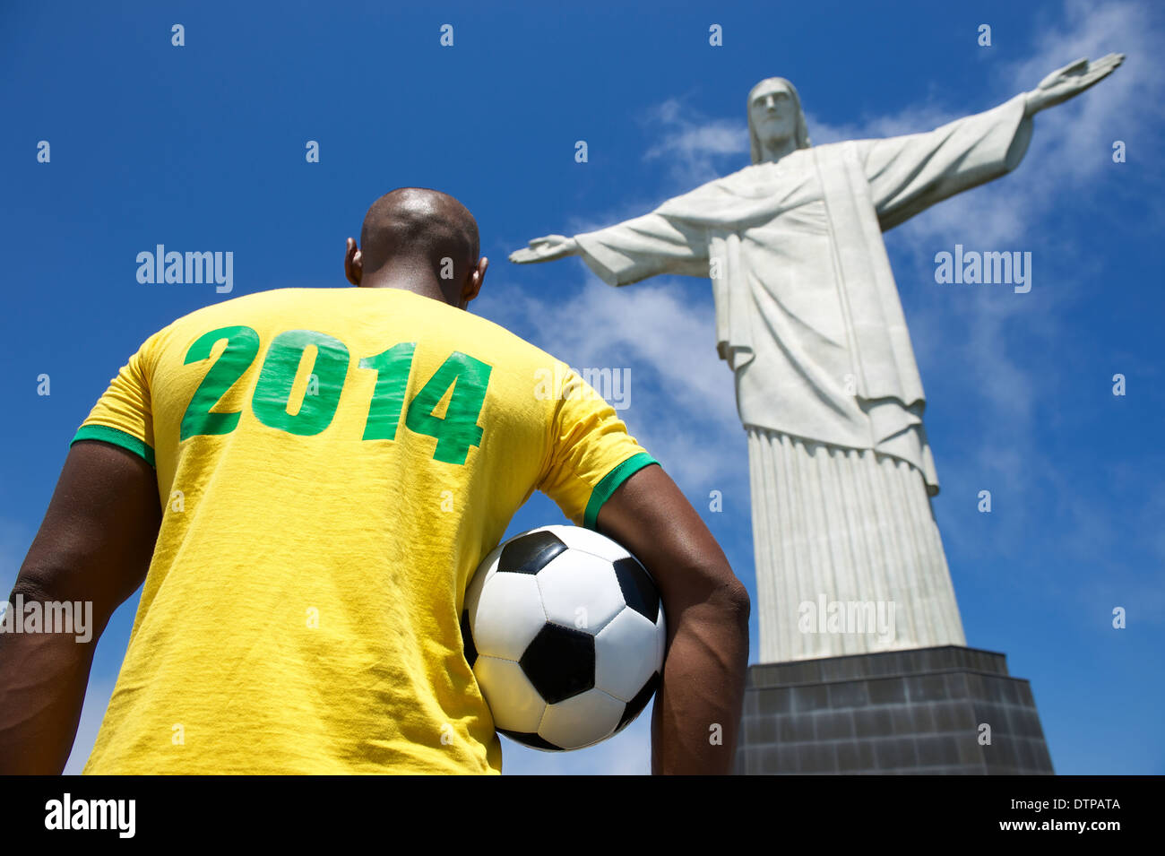 Brazilian football player in 2014 shirt holding soccer ball at Corcovado Cristo Redentor Rio de Janeiro Stock Photo