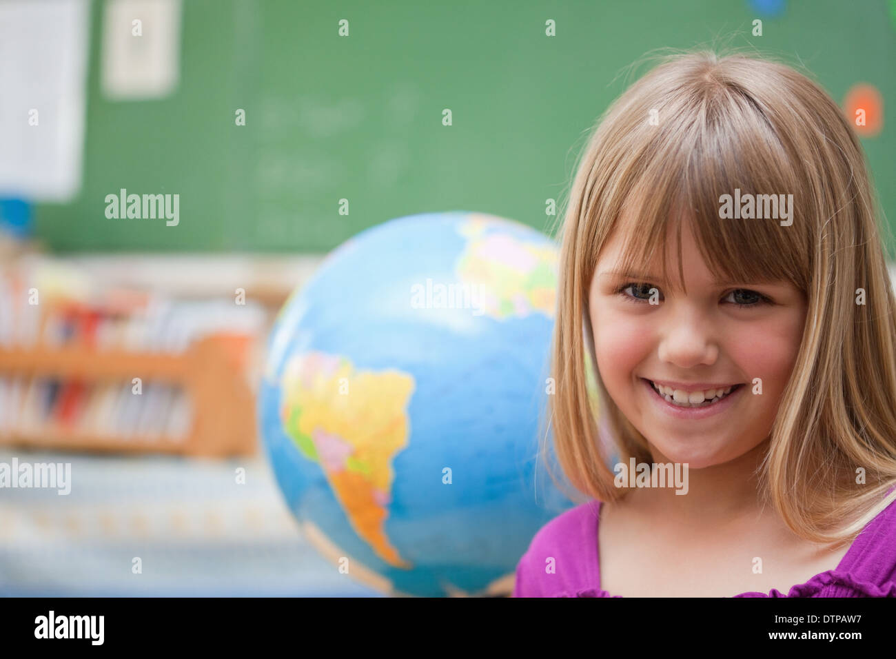 Schoolgirl posing in front of a globe Stock Photo - Alamy