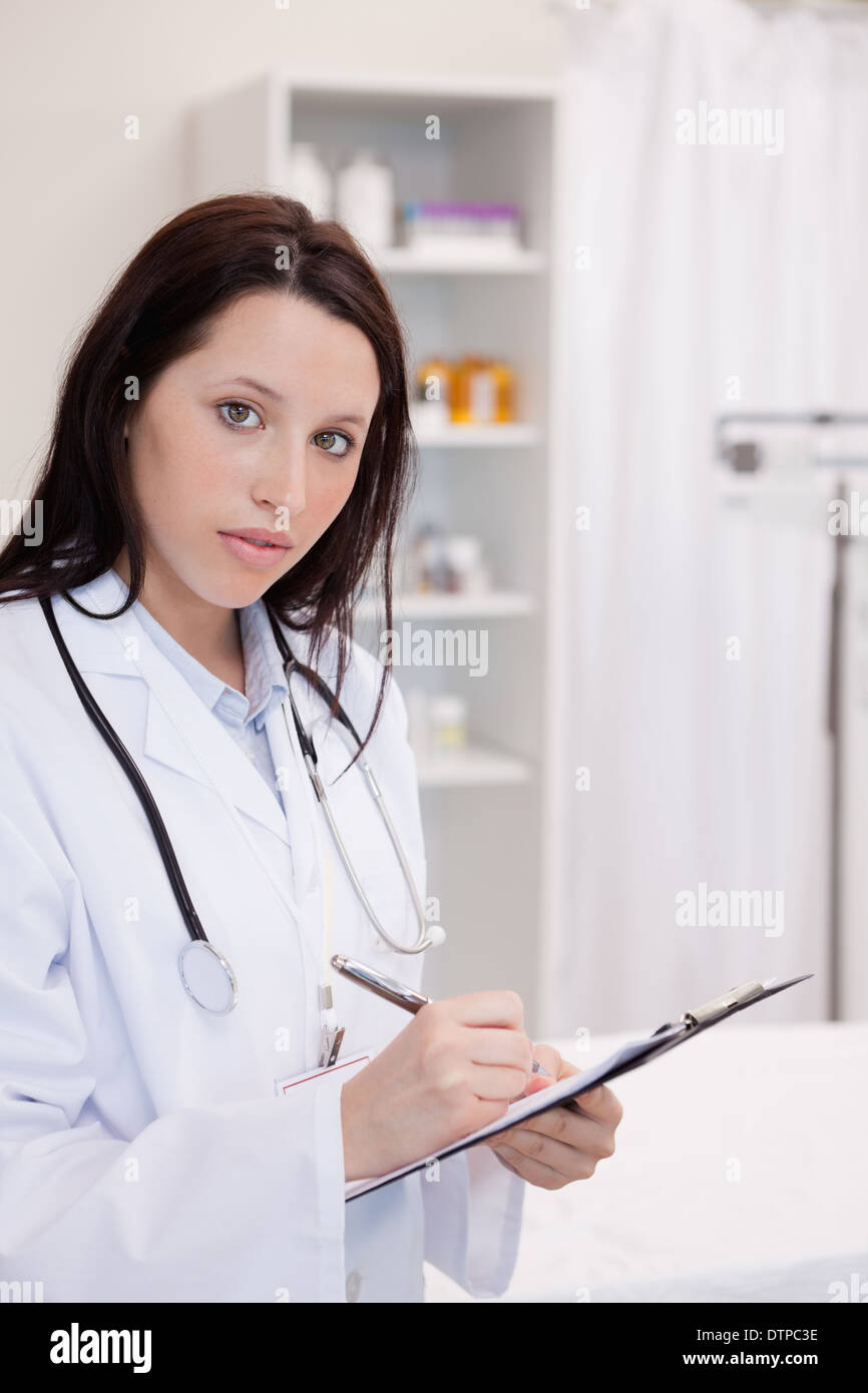 Female doctor writing on her notepad Stock Photo - Alamy