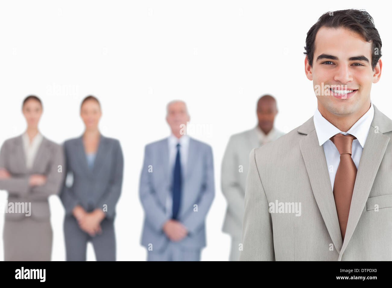 Smiling salesman with colleagues behind him Stock Photo - Alamy
