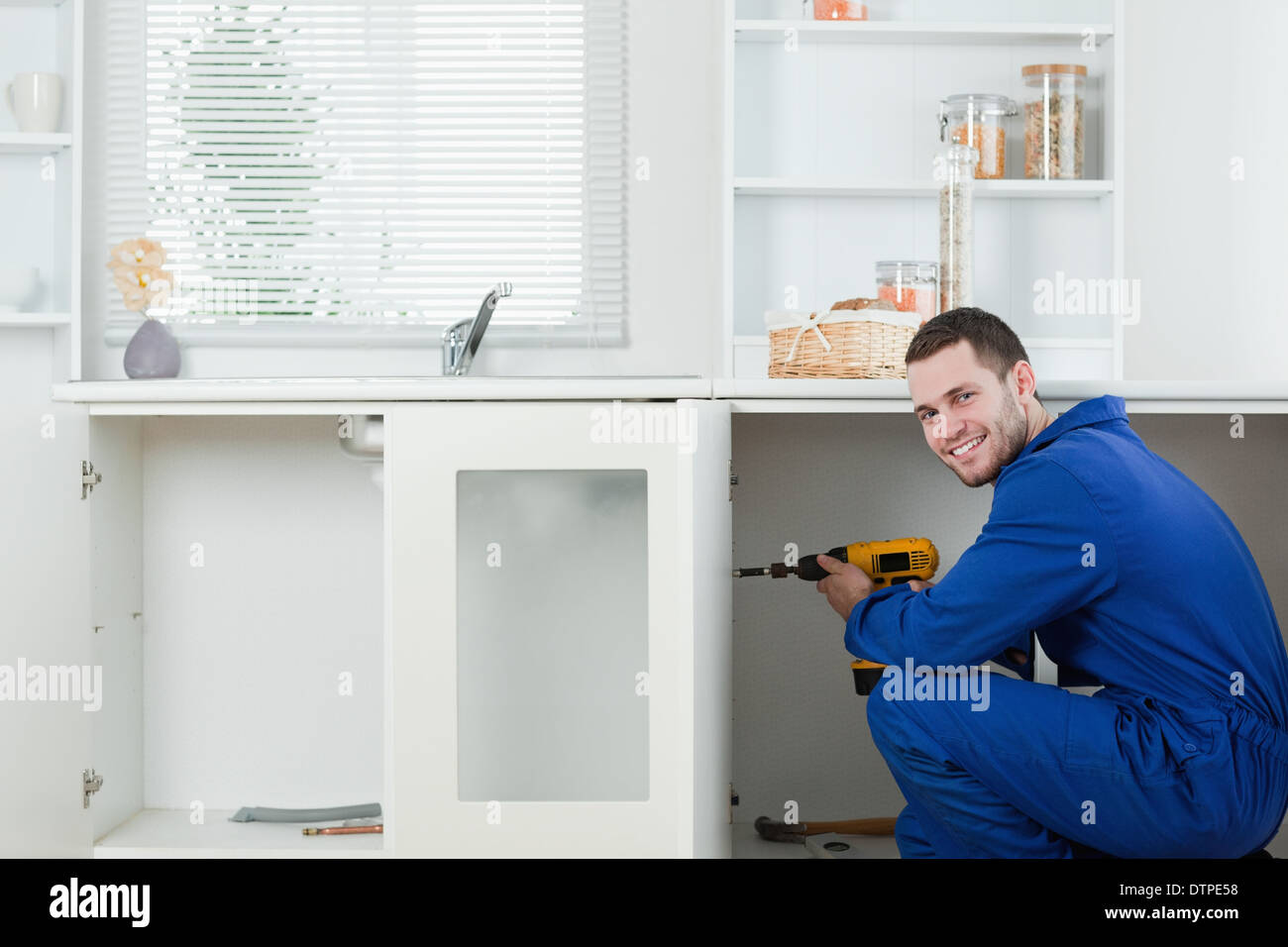 Smiling handyman fixing a door Stock Photo