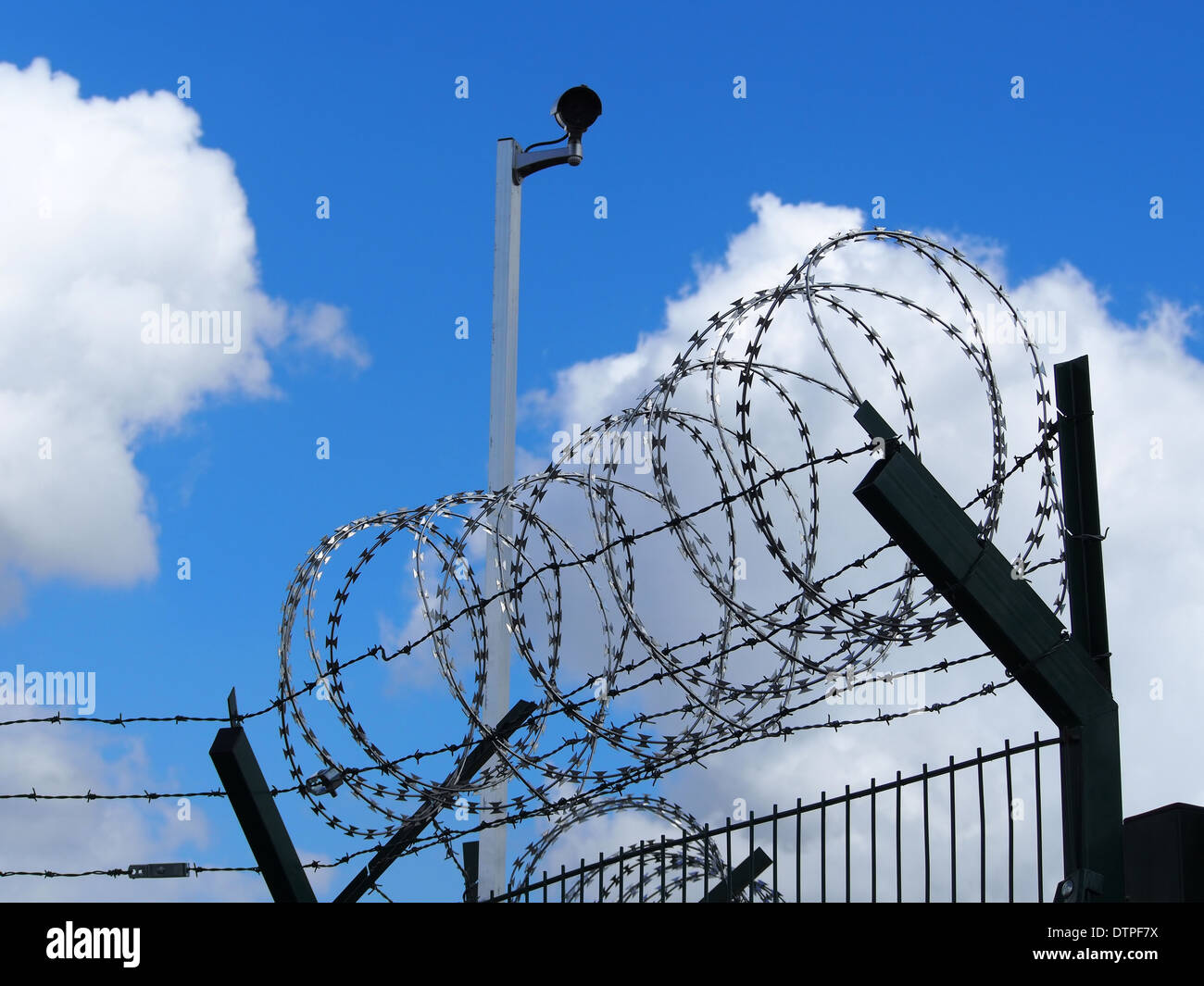 Restricted area - fence with barbed wire and camera Stock Photo - Alamy