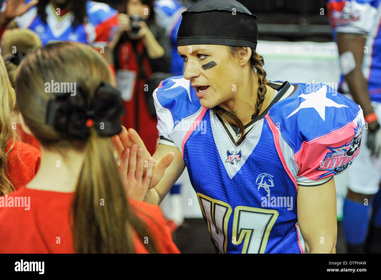 Allen, TX, USA. 21st Feb, 2014. Texas Revolution running back Jennifer Welter high-fives a group of children as they exit the field prior to the Revolution playing the Cedar Rapids Titans in an Indoor Football League game at the Allen Event Center Friday, February 21, 2014, in Allen, Texas. The 5-foot-2-inch, 130 pound Welter is the first woman to play professional football at a position other than kicker, she made the final roster of the Texas Revolution of the Indoor Football League, as a running back. © csm/Alamy Live News Stock Photo