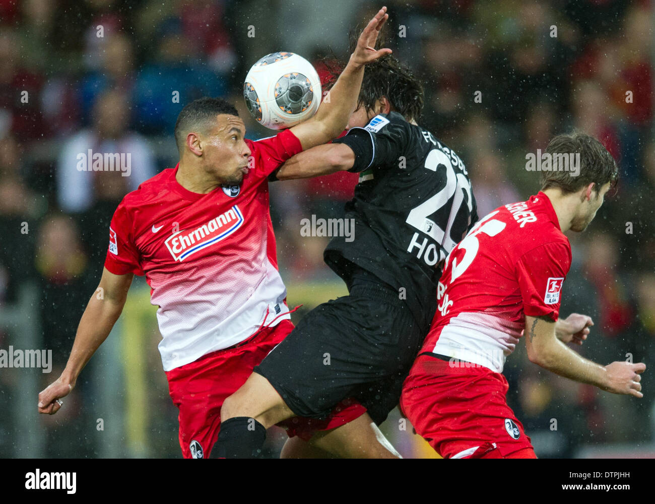 Freiburg, Germany. 22nd Feb, 2014. Freiburg's Philipp Zulechner (R) and Francis Coquelin (L) in action against Augsburg's Jeong-Ho Hong during the soccer Bundesliga match bewteen Sport-Club Freiburg and FC Augsburg at the Mage-Solar-Stadion in Freiburg, Germany, 22 February 2014. Photo: UWE ANSPACH/dpa (ATTENTION: Due to the accreditation guidelines, the DFL only permits the publication and utilisation of up to 15 pictures per match on the internet and in online media during the match.)/dpa/Alamy Live News Stock Photo