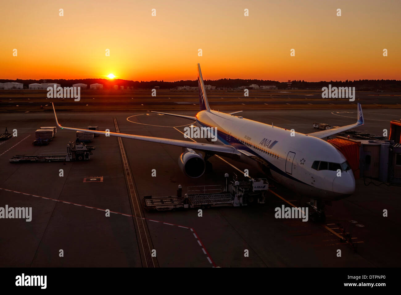 Air Japan jet at a gate of Narita International Airport, Tokyo, Japan, at sunset. Stock Photo