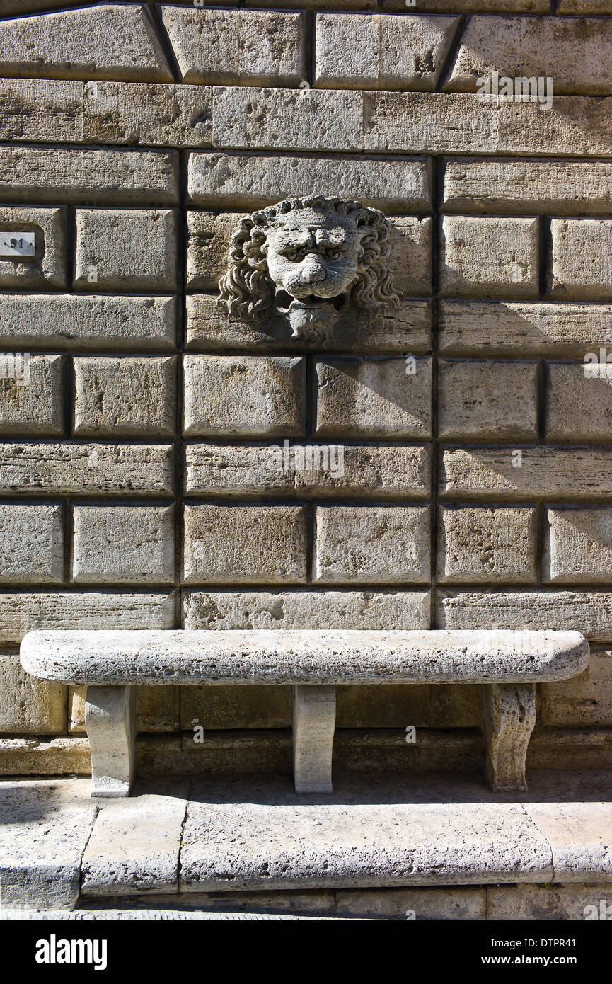 Lion head sculpture and stone bench seat on the wall of Palazzo Avignonesi, Montepulciano, Tuscany, Italy Stock Photo