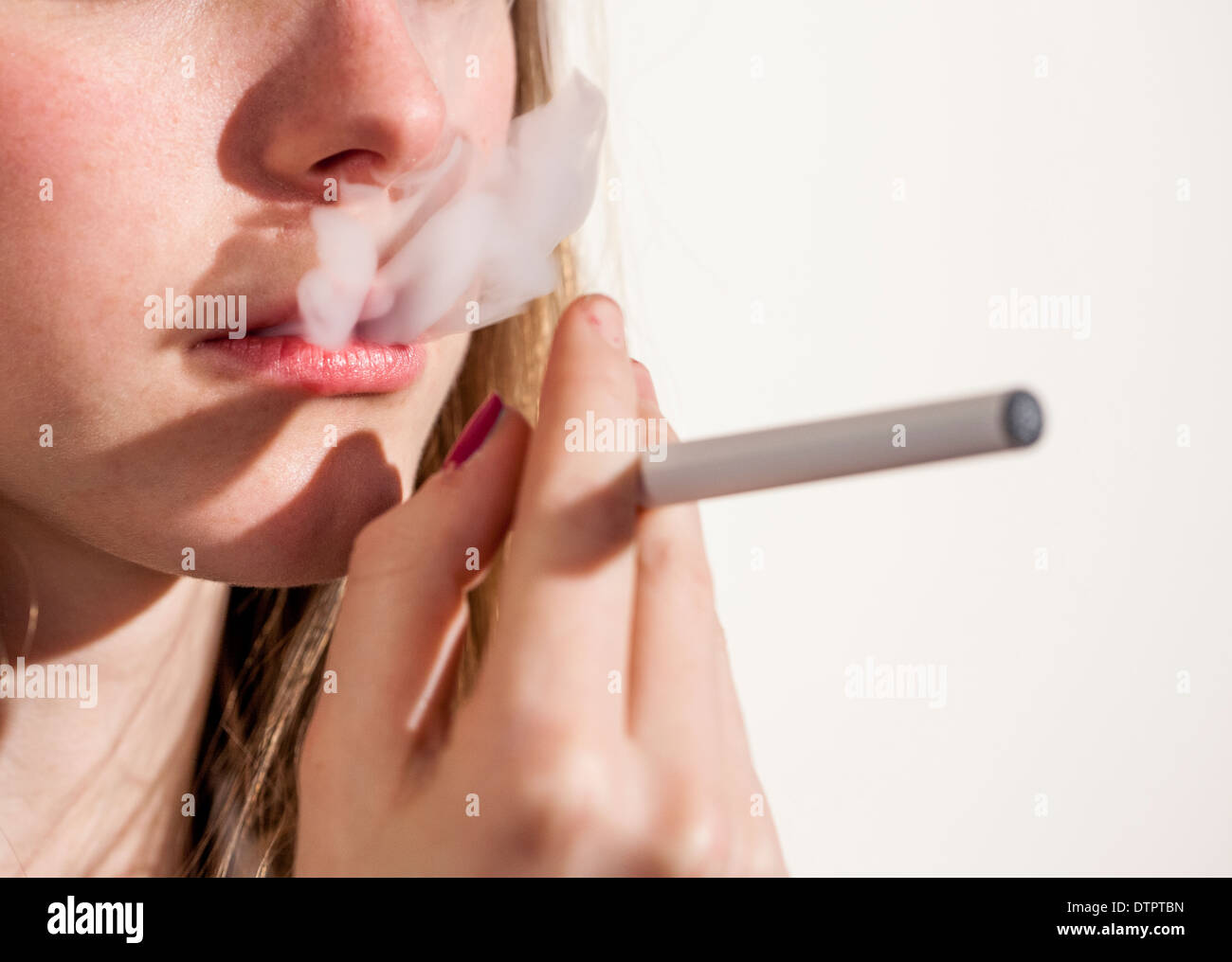 Young teenage girl smoking e or electronic cigarette, image is anonymous Stock Photo