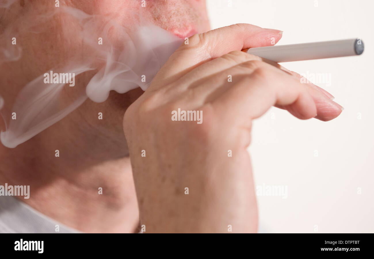 smoking or vaping an E or electronic cigarette Stock Photo