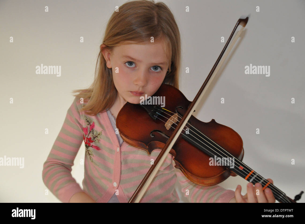 Cute little blonde girl plays her violin Stock Photo