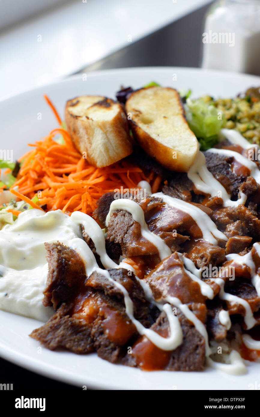 Iskender kebab a popular Turkish dish of lamb served with Turkish bread, rice, vegetables couscous and yoghurt Stock Photo