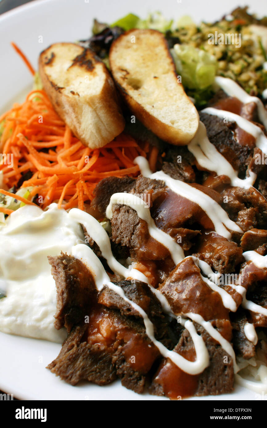Iskender kebab a popular Turkish dish of lamb served with Turkish bread, rice, vegetables couscous and yoghurt Stock Photo