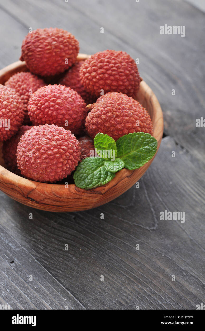Fresh lychee in bowl on a wooden background Stock Photo