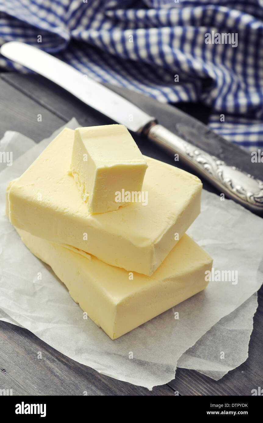 Fresh butter on wooden cutting board with knife closeup Stock Photo