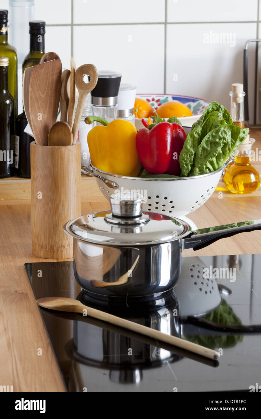 Cooking Pot and Cooking Spoon on Ceramic Hob and other Kitchen Utensils