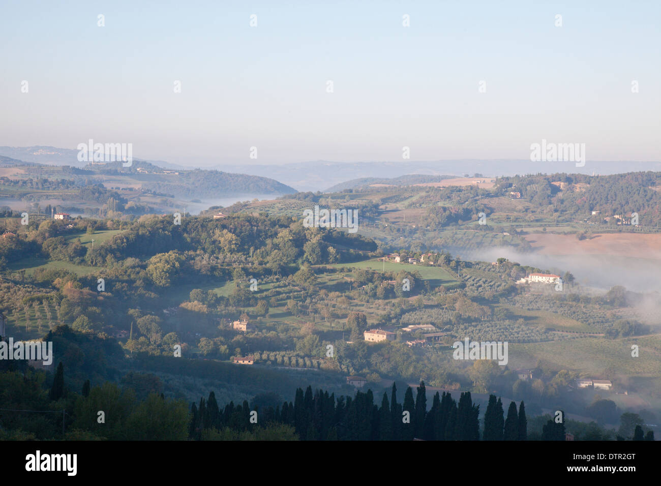 Morning mist and sunlight on the slopes in the valley below Montepulciano, Tuscany, Italy. Mandatory credit Jo Whitworth Stock Photo