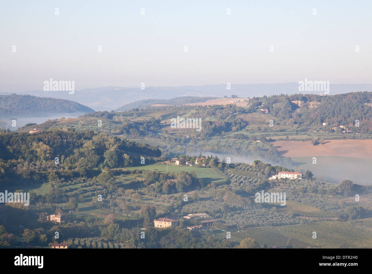 Morning mist and sunlight on the slopes in the valley below Montepulciano, Tuscany, Italy. Mandatory credit Jo Whitworth Stock Photo