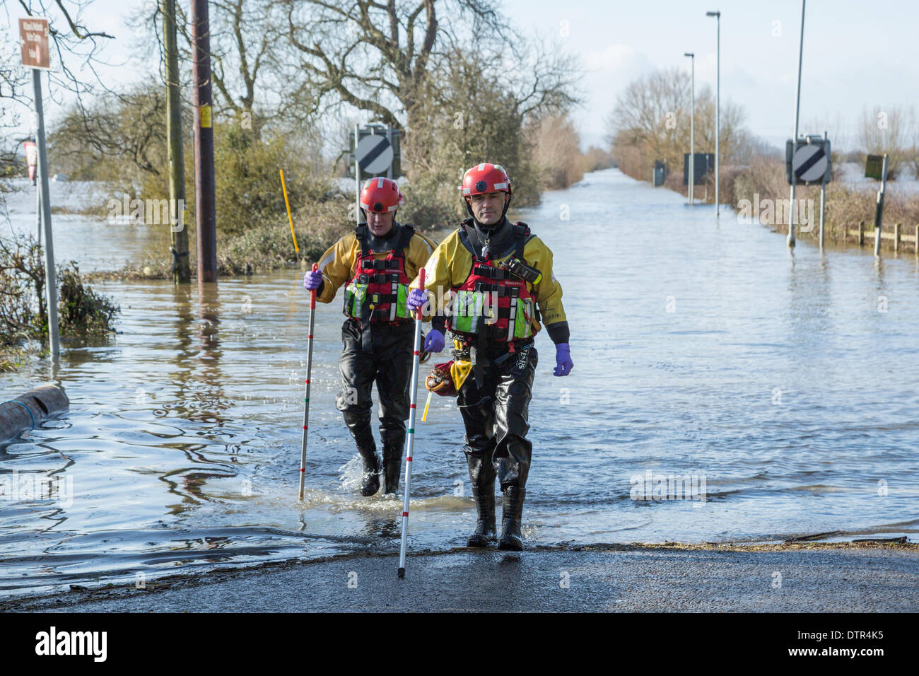 Burrowbridge, UK. 22nd Feb, 2014. Officers from Somerset's Fire & Rescue service wade into floodwater at Burrowbridge on February 22, 2014. Dressed in waders and lifejackets, two men walk along the carriageway of the A361, now totally submerged by floodwater during the heaviest flooding in living history on the Somerset Levels. They are using measuring sticks to determine the current depth of water along the carriage which currently stands at 1.1 metres at this crossroad. Credit:  Nick Cable/Alamy Live News Stock Photo