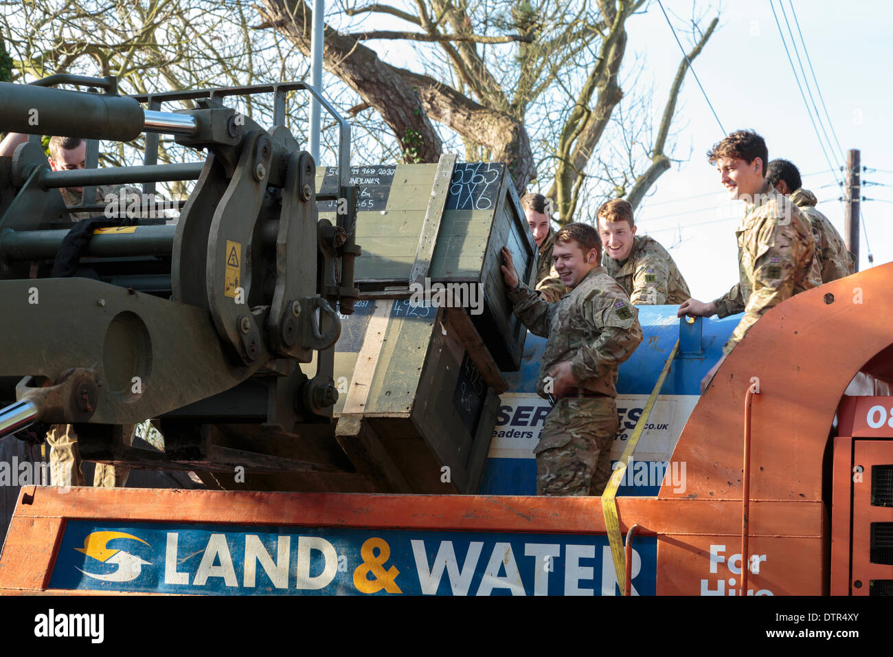 Burrowbridge, UK. 22nd Feb, 2014. Commandos helping at Burrowbridge on the flooded Somerset Levels on February 22, 2014. A group of soldiers load crates of supplies onto an Environment Agency Trac-dumper, a specialised vehicle capable of going through deep water. Supplies of oil and mechanical parts are sent to Saltmoor Pumping Station where water from Northmoor is being pumped into the tidal River Parrett to provide relief to the flooded area.These are the worst floods on the Somerset Levels in living history. Stock Photo