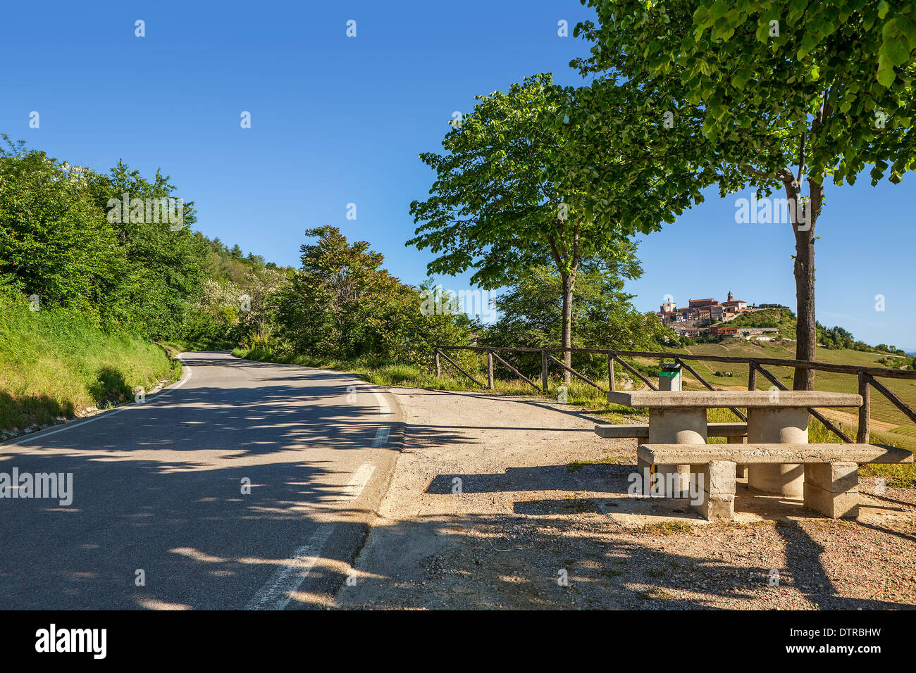 Narrow asphalt road and little resting area on the roadside in Piedmont, Italy. Stock Photo