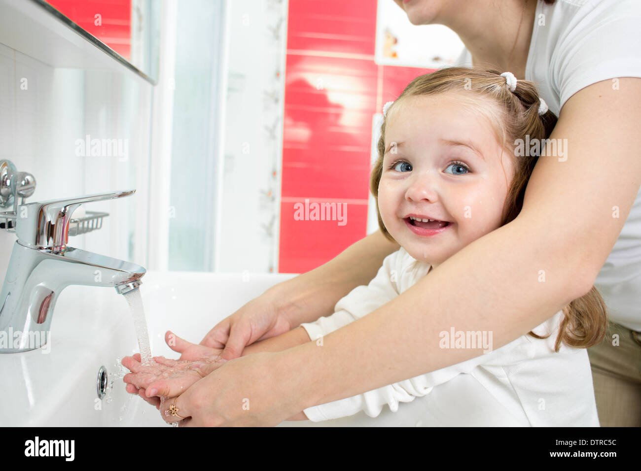Kid washing hands in bathroom Stock Photo