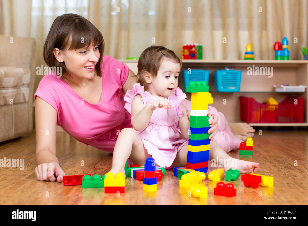 mother and her daughter play with toys at home interior Stock Photo
