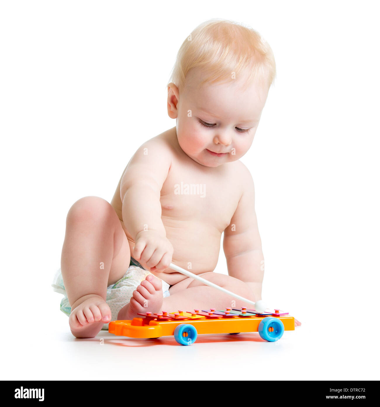 funny baby boy playing with musical toys Stock Photo
