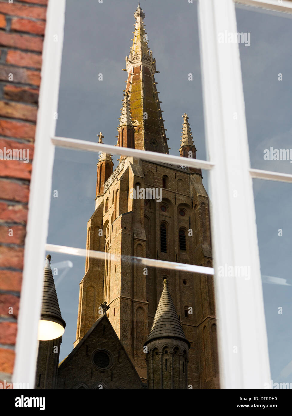 Reflection in window of the tower of Spire of Church of our Lady, Bruges (Onze Lieve Vrouwekerk, Brugge) Stock Photo
