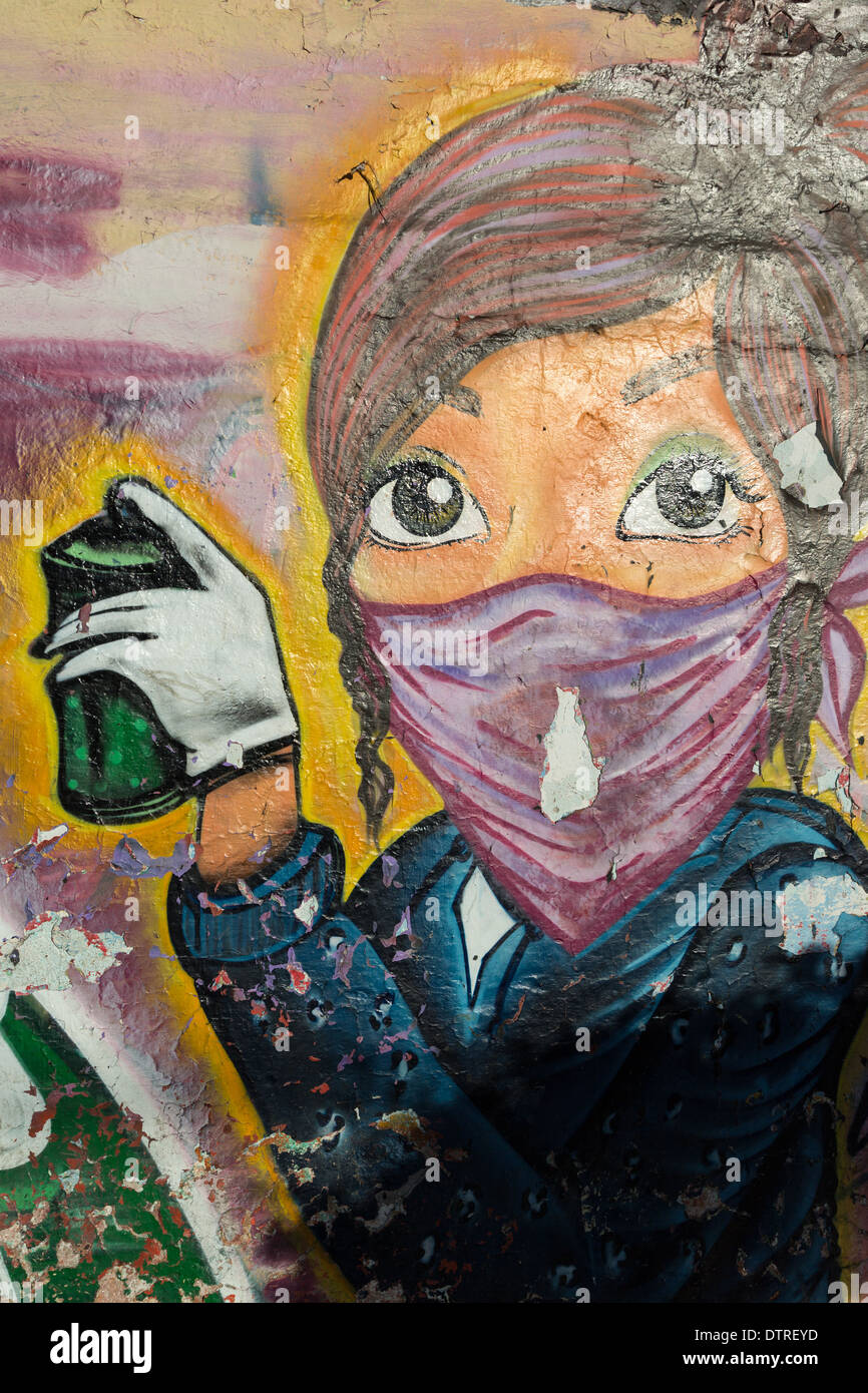 Street art depicting a young artist girl woman with spray paint along a ...