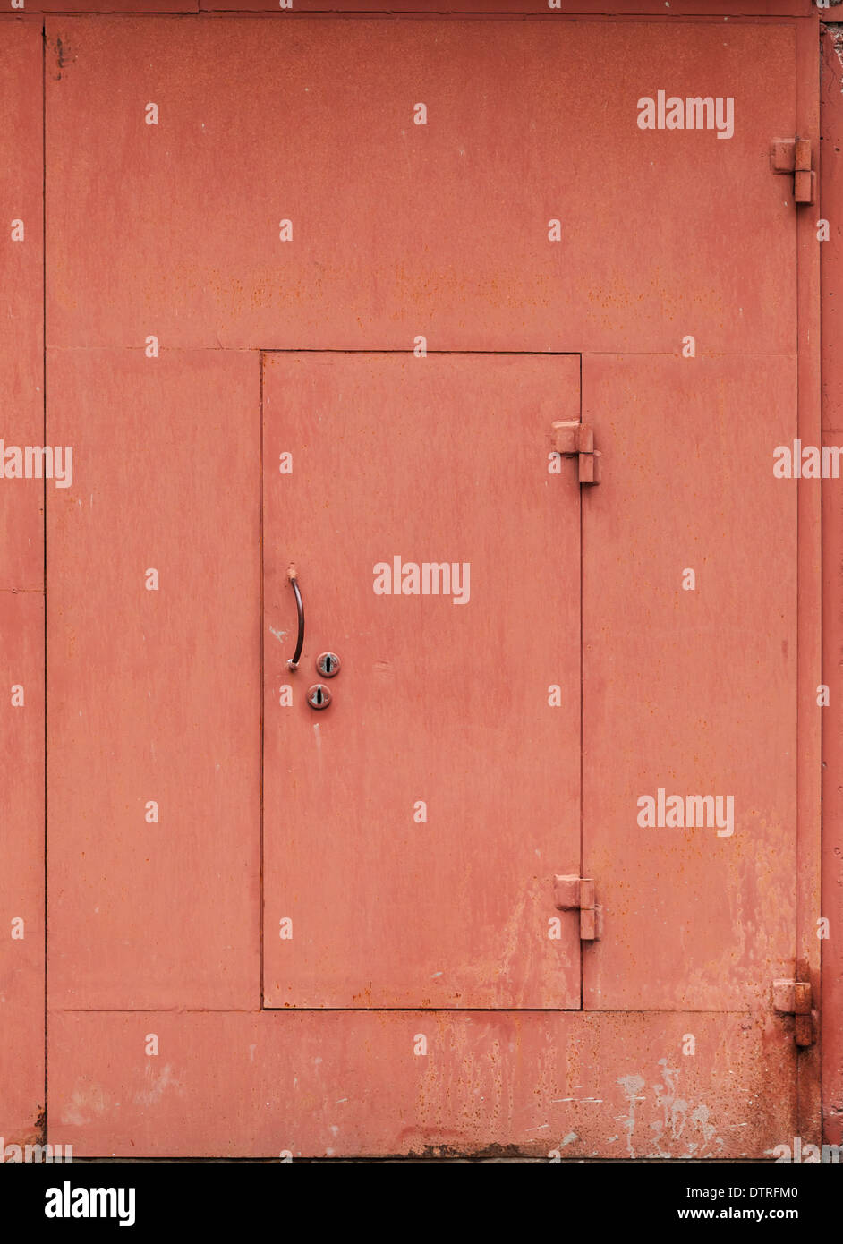 Red metal garage wall with locked door. Background texture Stock Photo
