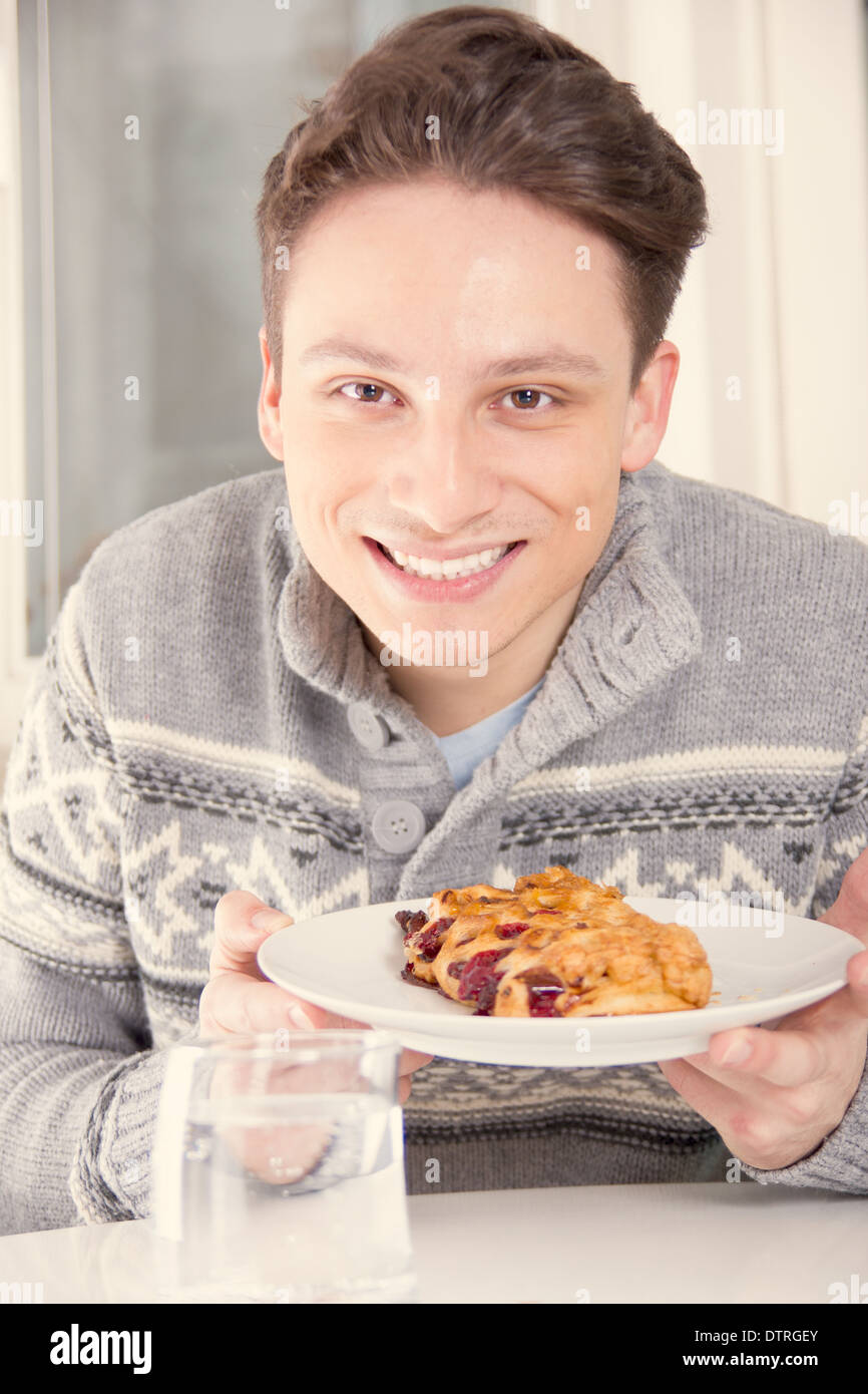 young smiling man holding dessert on the plate, warm effect Stock Photo