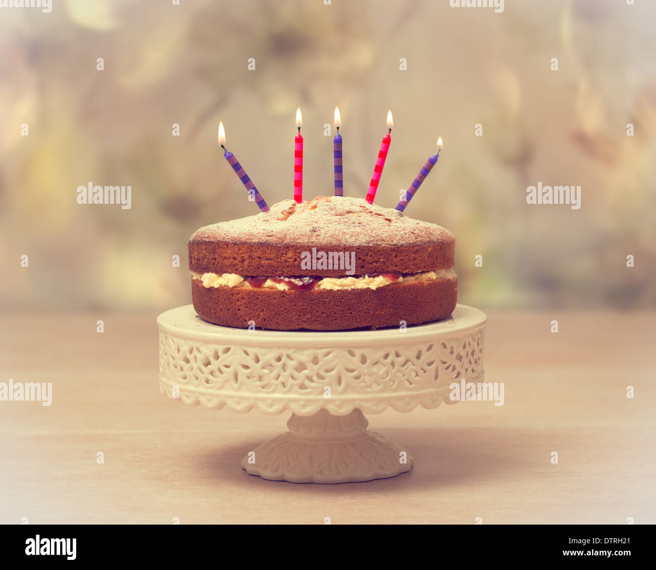 Victoria sponge Birthday cake with lit candles antique vintage tone