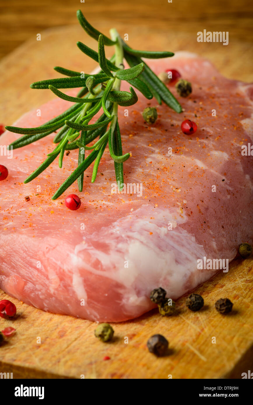 closeup of raw pork meat steak with rosemary and pepper Stock Photo