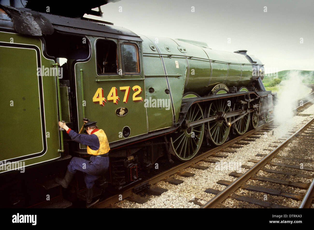 Train driver climbing aboard the Flying Scotsman steam locomotive pulling The North Yorkshireman 1981 Stock Photo