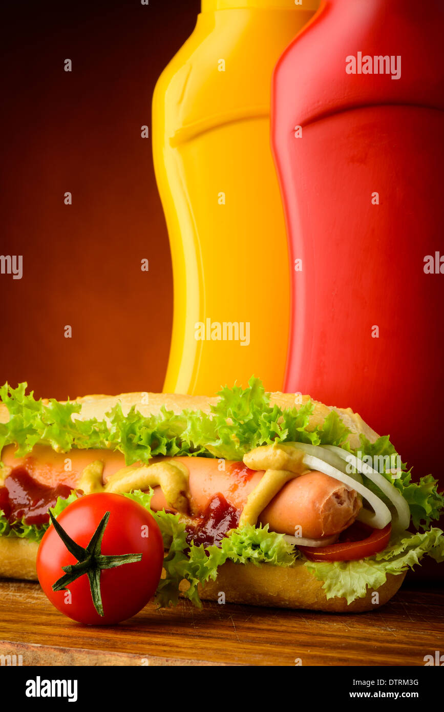 still life with traditional hotdog, ketchup, mustard and vegetables Stock Photo