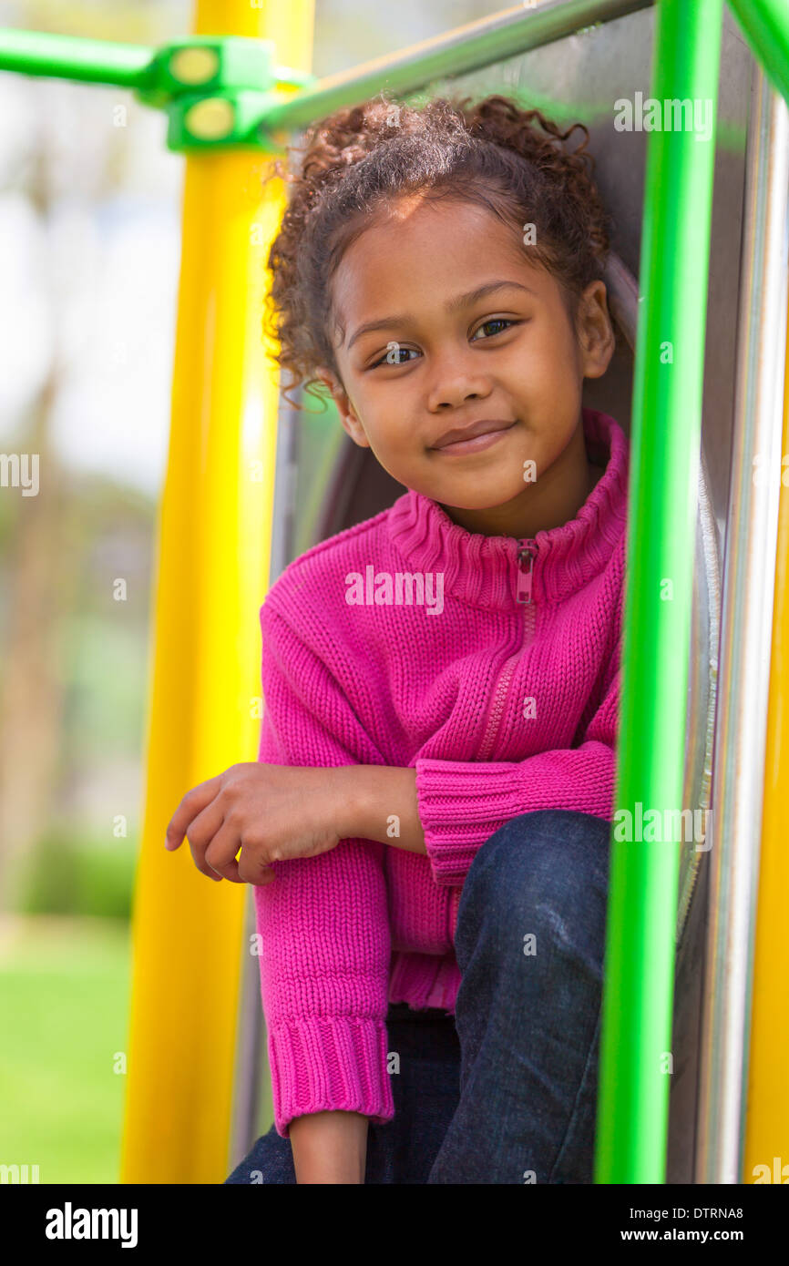 Outdoor portrait of a cute african american little girl playing at ...