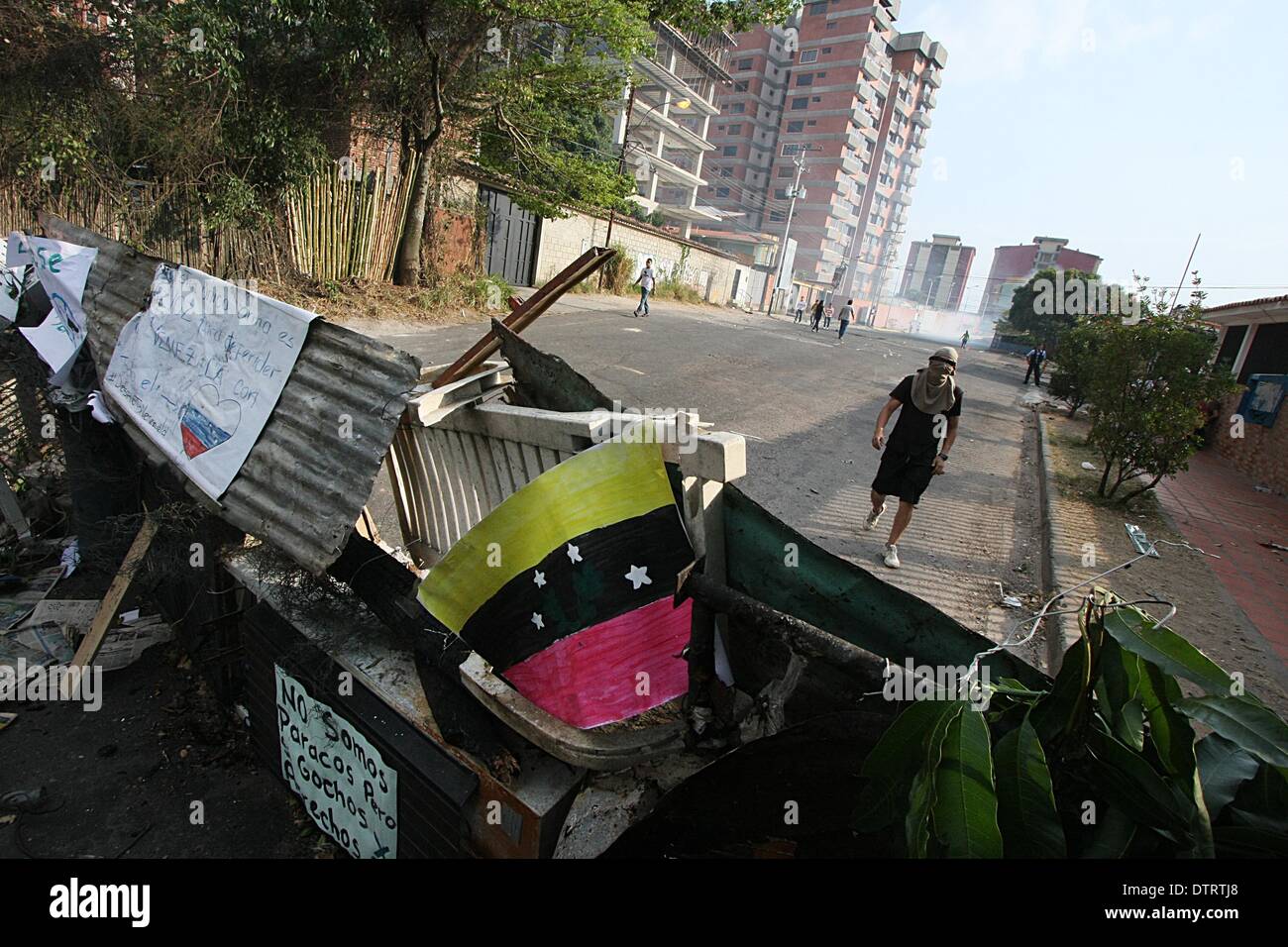 Tachira, Venezuela. 23rd Feb, 2014. A demonstrator stands in front of the wreckages on a street after the protests in San Cristobal, Tachira state, Venezuela, on Feb. 23, 2014. Credit:  George Castro/Xinhua/Alamy Live News Stock Photo
