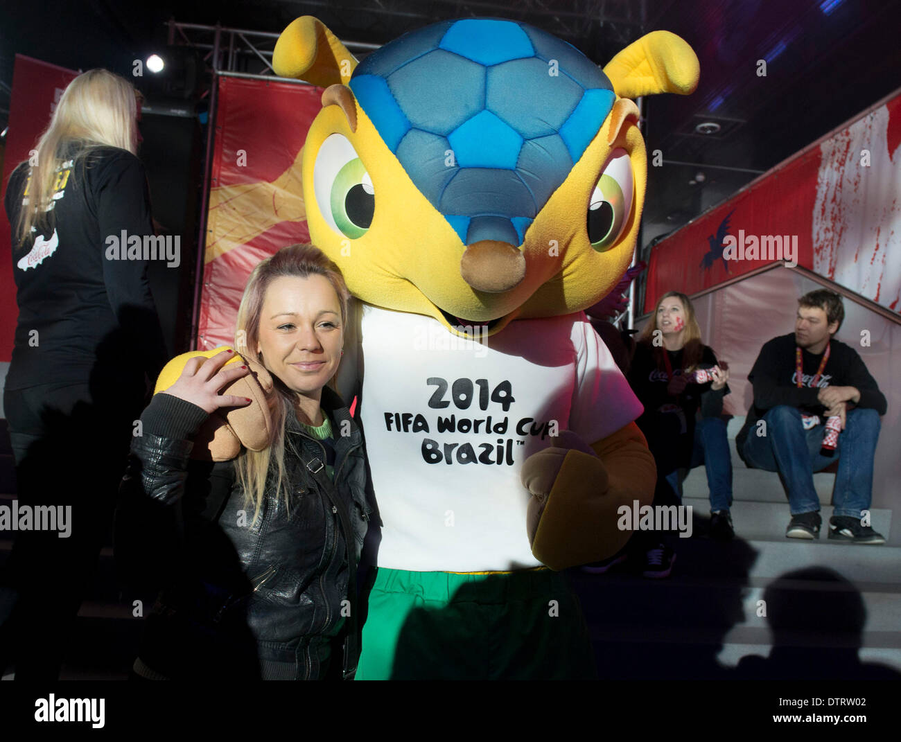 Zagreb, Croatia. 23rd Feb, 2014. A woman poses for a photo with Fuleco, the official mascot of the 2014 FIFA World Cup Brazil, during the FIFA World Cup trophy presentation in Zagreb, capital of Croatia, Feb. 23, 2014. The FIFA World Cup Trophy tour began its journey in September 2013 and will end in April 2014 in Brazil. © Miso Lisanin/Xinhua/Alamy Live News Stock Photo